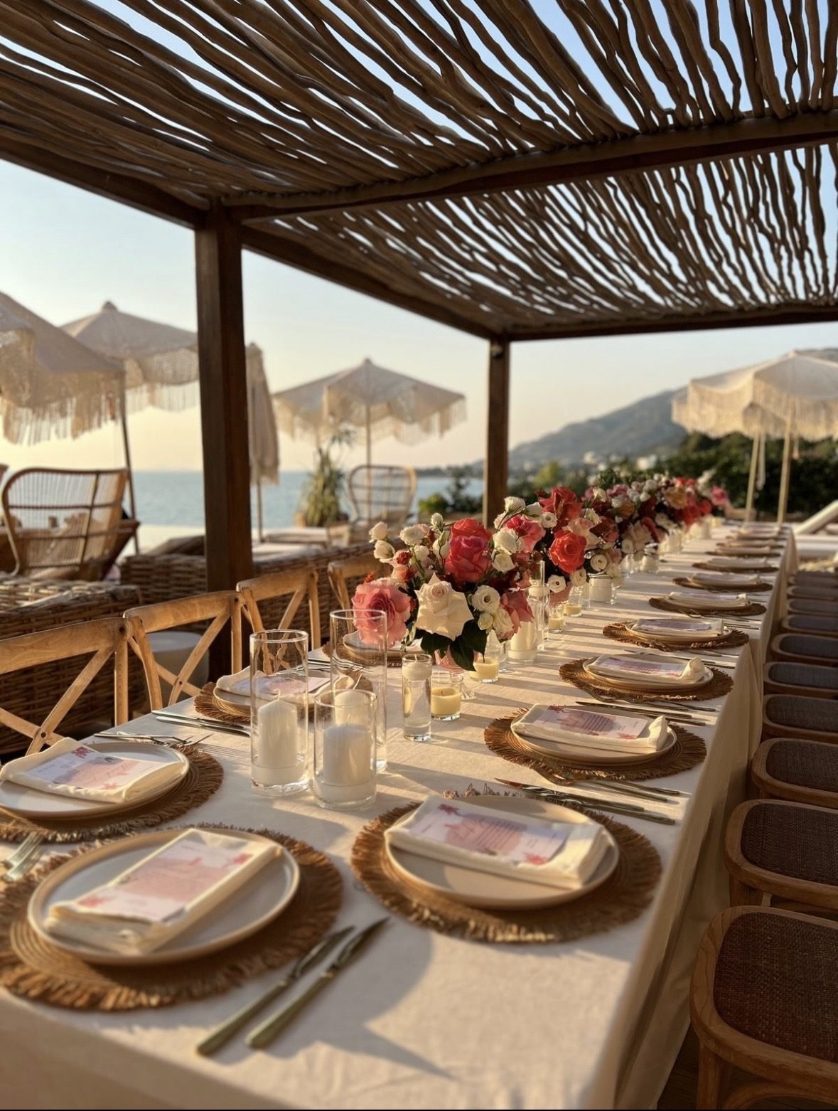 Bojo Resort Orikum — lange Tafel unter Strohpergola mit Rosengestecken und Meerblick