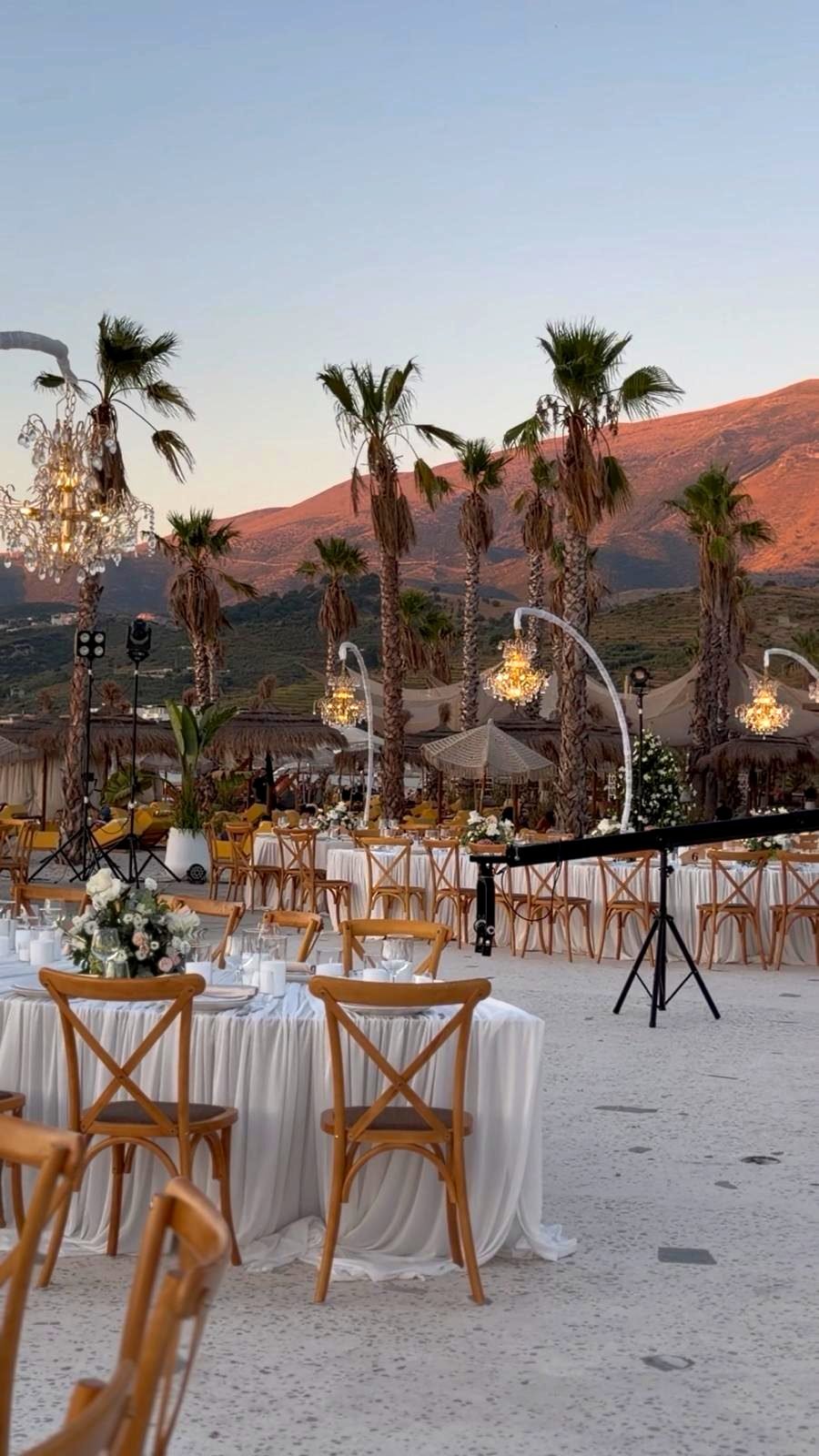 Bojo Resort Orikum — Empfangsbereich zwischen Palmen mit Kristallleuchtern in der Abenddämmerung